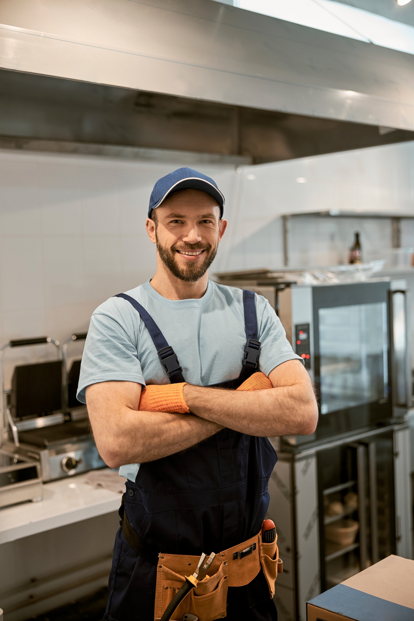 Joyful male worker standing in cafe kitchen